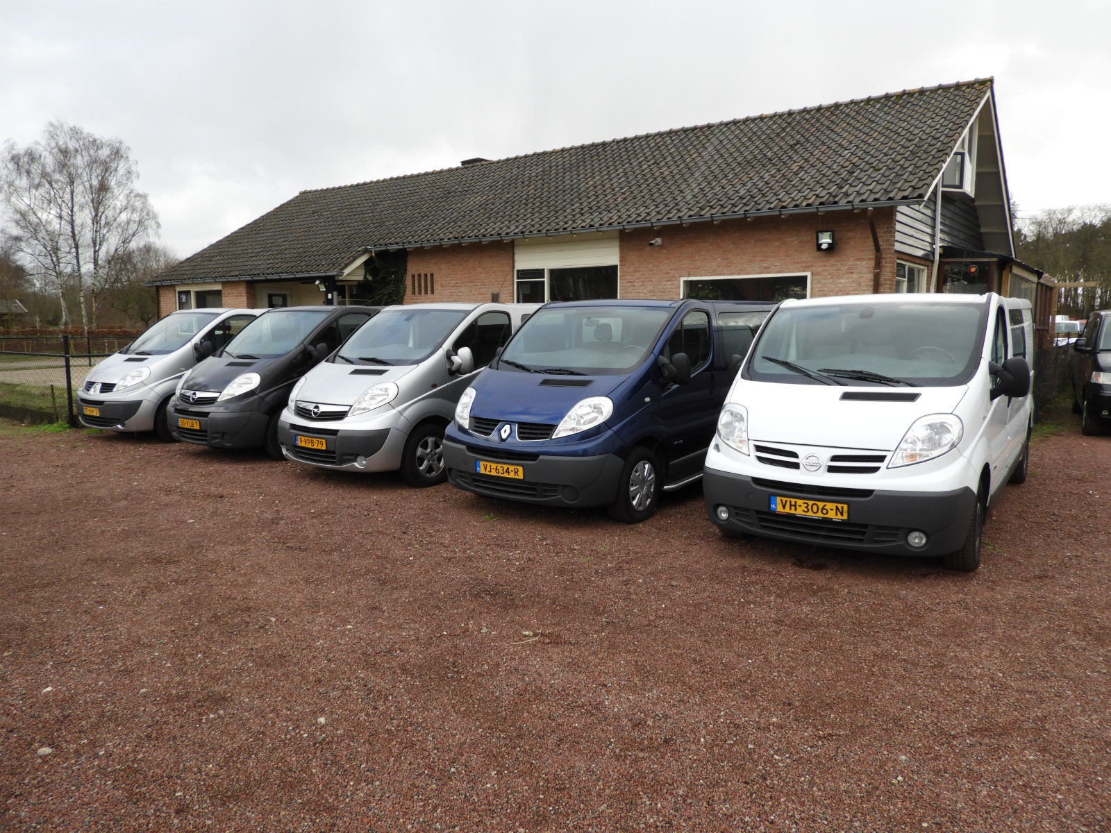 Meerdere bestelwagens op een rij op een parkeerplaats