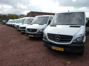 Meerdere witte bestelwagens op een rij op een parkeerplaats
