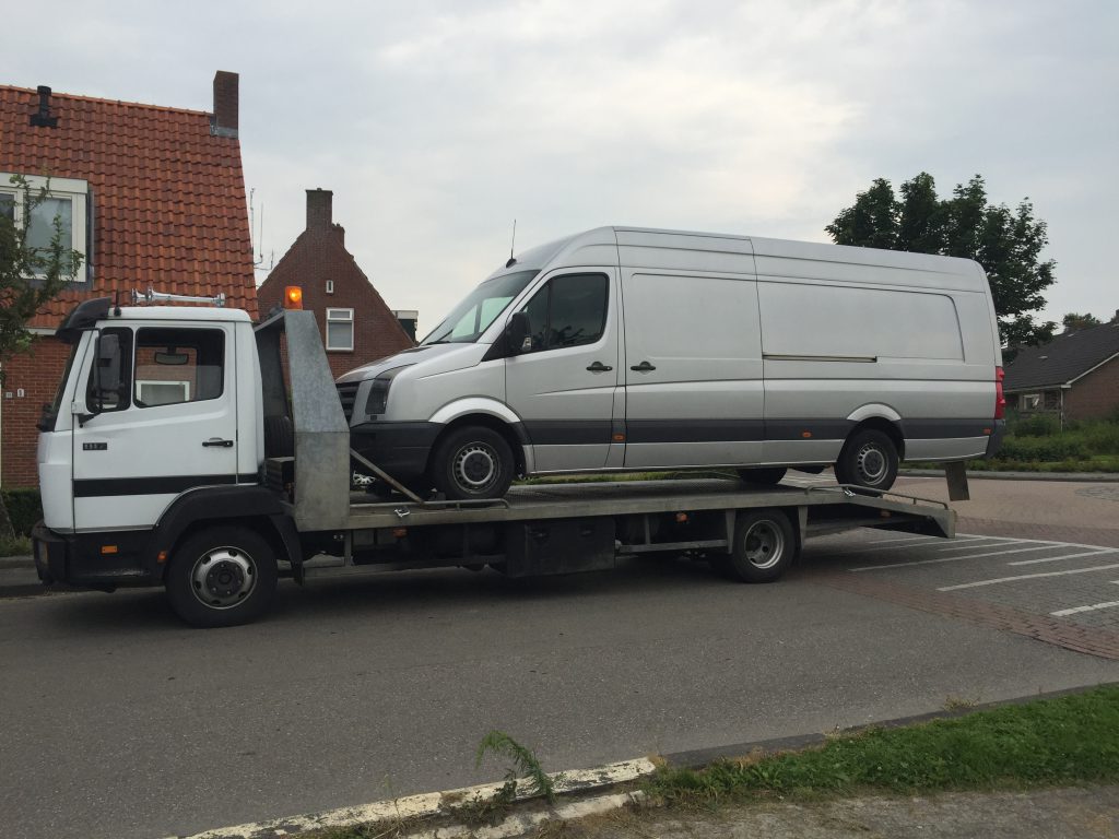 Een witte bestelwagen achterop